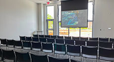 Chairs lined up in front of projector screen and window