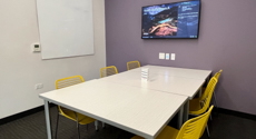 Photo of Youth Study Room D with a Table, Monitor Screen, six chairs and a dry erase board